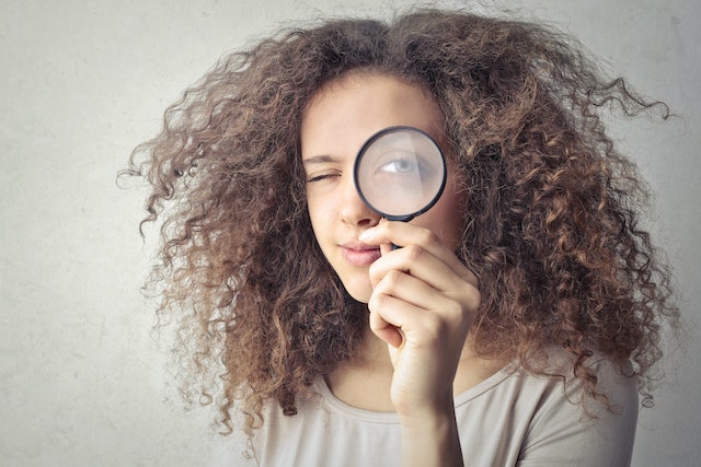 Personne avec une loupe devant son œil